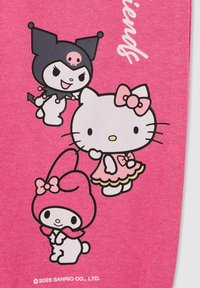 Tessuto rosa con tre personaggi dei cartoni animati: una ragazza in abito, un personaggio con un teschio e un coniglietto con un cappello, tutti contornati in nero.