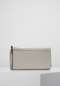 Stříbrná a šedá kabelka na ruku s kovovým vrškem a hladkým koženým tělem. Má řetízkový popruh a elegantní obdélníkový tvar.