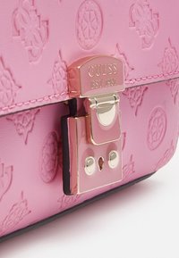 Borsa a manico rosa goffrata con hardware dorato, dotata di chiusura a gancio. Il design presenta un motivo logo sottile e un bordo nero a contrasto.
