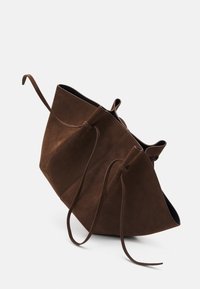 Brązowa torebka z zamszu o charakterystycznym trójkątnym kształcie i sznurkiem do ściągania. Posiada gładką fakturę oraz kontrastowe ciemne wnętrze.