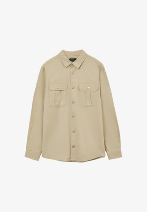 Helles beiges Hemd aus strukturiertem Stoff. Verfügt über eine Knopfleiste, einen spitzen Kragen und zwei Brusttaschen mit Druckknopfverschlüssen.