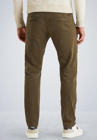 Olive green cargo pants with a tapered design, featuring back pockets and knee patches, paired with white sneakers on a light background.