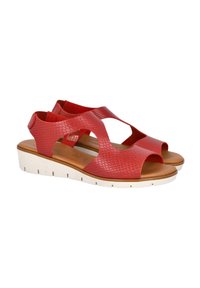 Sandalias rojas de cuero texturizado con punta abierta y diseño de tiras cruzadas; cuentan con una suela de color claro y estriada para mayor agarre.
