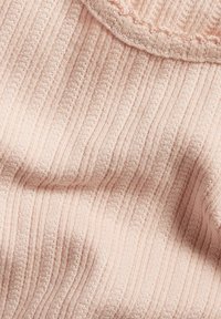 Strickstoff in sanftem Rosa mit vertikalem Ripptextur, ausgestattet mit einem runden Halsausschnitt und zarten Nähten an den Kanten.