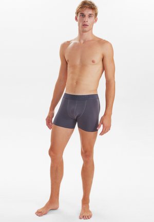 Boxer in cotone grigio con elastico a contrasto caratterizzato da logo in rilievo; design aderente; texture liscia e lunghezza fino a metà coscia.