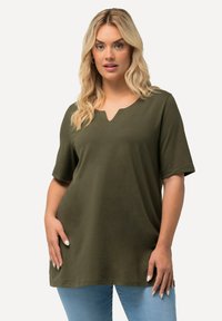 Top corto a maniche corte in verde oliva con scollatura a V e vestibilità rilassata. Realizzato in tessuto morbido, caratterizzato da una texture liscia e senza motivi visibili.