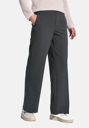Pantaloni grigi a gamba larga realizzati in un tessuto morbido. Presentano tasche laterali e una vestibilità dritta, abbinati a sneakers bianche.