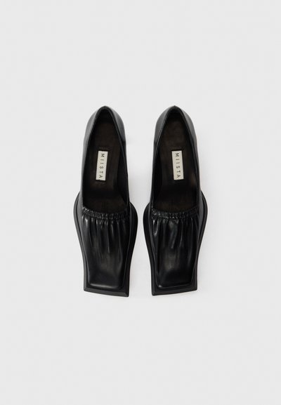 Pair of black leather slip-on shoes with gathered details, square toes, and branded insole reading "MIISTA" on a white background.
