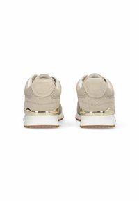 Baskets en daim beige avec un accent métallique doré lisse sur le talon, une semelle intermédiaire blanche et une semelle extérieure en caoutchouc texturé.