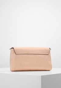 Borsa clutch rettangolare in pelle rosa pallido con chiusura a pattina, cuciture visibili e anelli metallici su ciascun lato, esposta su un piedistallo bianco.