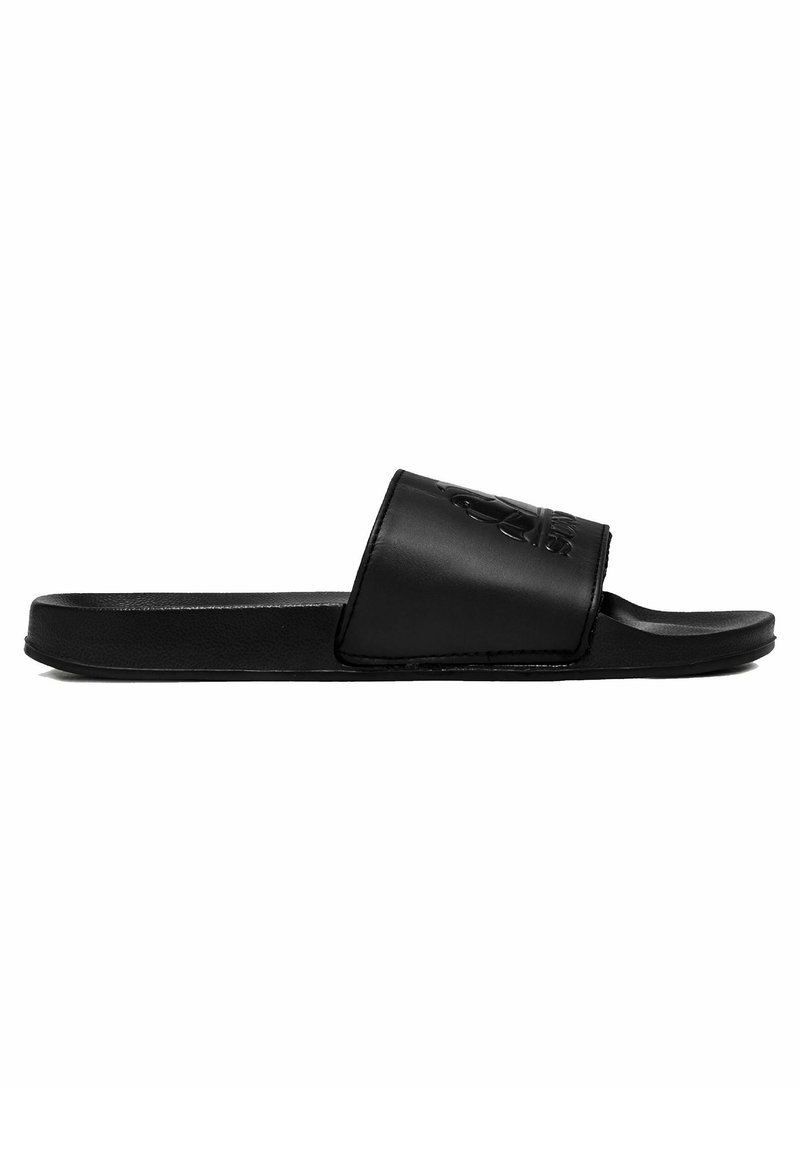 Sandal nera a ciabatta con una superficie liscia e opaca, dotata di un logo in rilievo sulla fascia. Ha una suola piatta e un design con punta aperta.