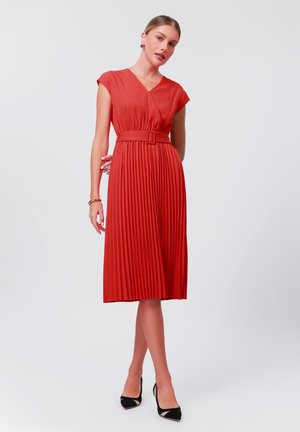 Red pleated dress with a V-neck, short sleeves, and a belted waist. The fabric is smooth, and the hem falls below the knee.