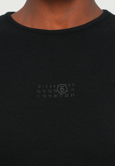 Black ribbed t-shirt with a round neckline. Features a faded printed design of numbers and a circular symbol on the front.