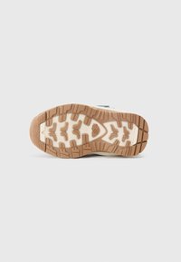Suela de zapato con una base de goma marrón y un dibujo en el tread para mayor agarre. La entresuela es blanca, en contraste con la suela marrón.