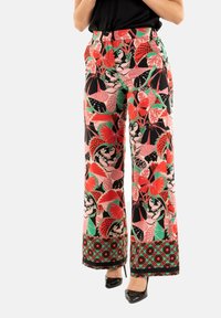 Pantalons larges ornés d'un motif floral vibrant en rouge, rose, vert et noir, avec une garniture décorative à l'ourlet. Fabriqués en tissu léger.