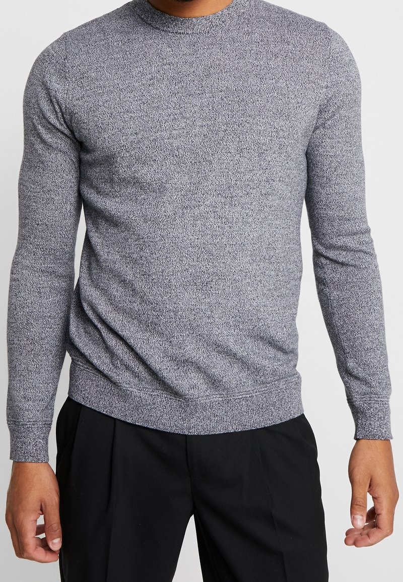 Szary sweter z okrągłym dekoltem, długi rękaw, wykonany z fakturowanej dzianiny. Ma ściągacze u dołu i na mankietach, co zapewnia dopasowane wykończenie.