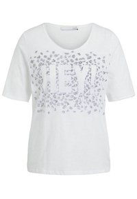 Witte blouse met korte mouwen en ronde halslijn, versierd met zilveren luipaardvlekken en het woord "HEY!" in grote letters op de voorkant.