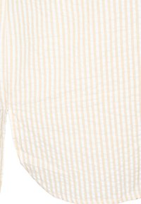 Tissu beige et blanc à rayures verticales avec un ourlet incurvé et une ouverture de couture latérale.