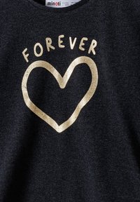 Tamno sivi majica s zlatnim metalnim srcem i riječi "FOREVER" ispisane velikim slovima iznad srca. Mekana tekstura, ležeran kroj.