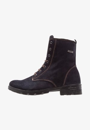 Bottine à lacets en daim noir avec coutures marron, œillets en métal et petit talon empilé.