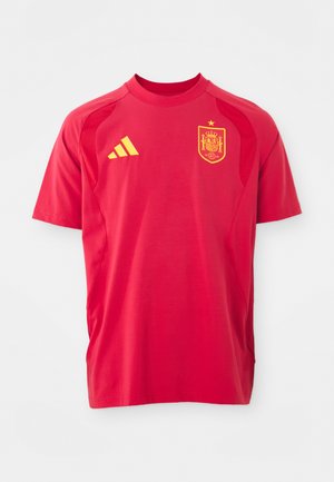 Crvena sportska majica izrađena od lagane tkanine, sa okruglim izrezom, kratkim rukavima, žutim Adidas logotipom i grbom reprezentacije Španije.
