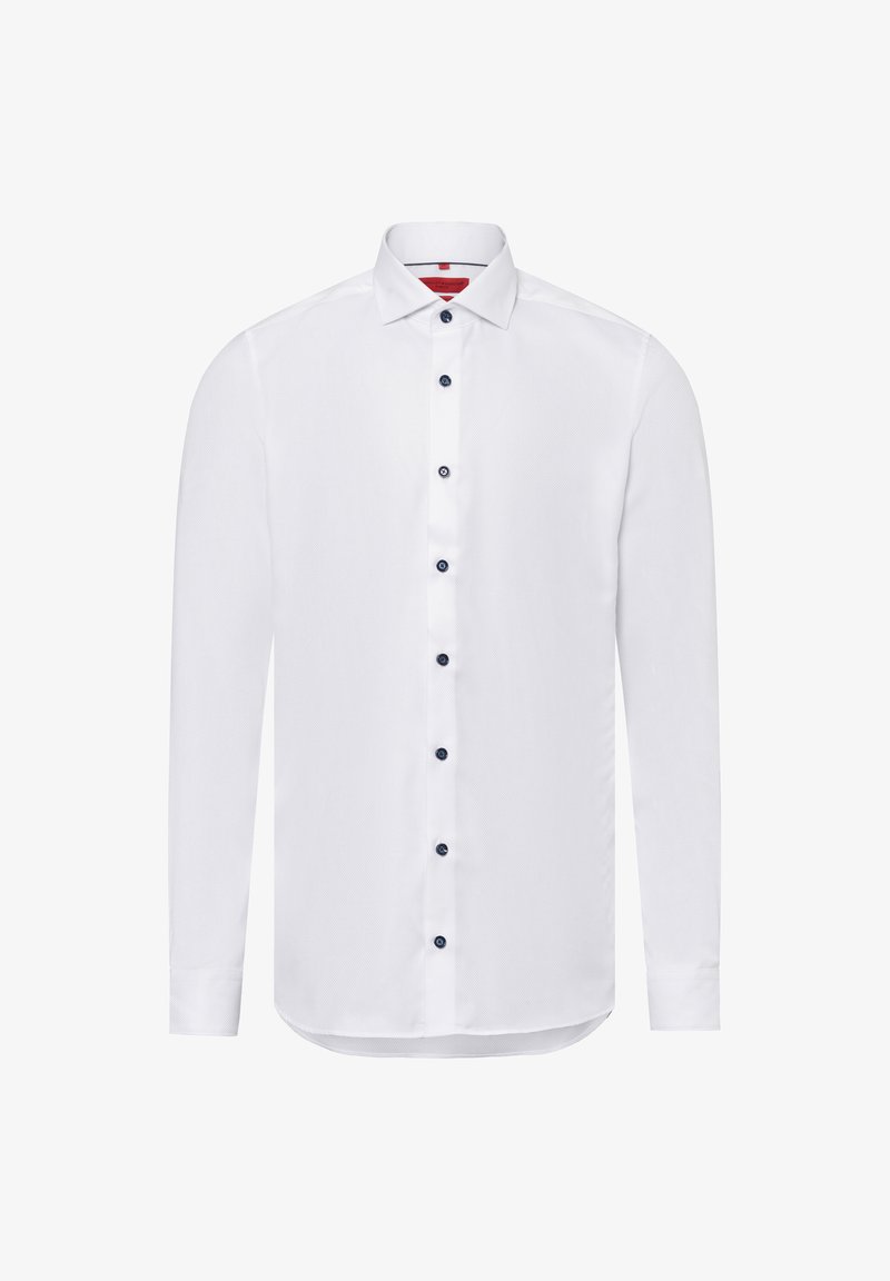 Witte blouse met lange mouwen en een textuurpatroon, voorzien van een spitse kraag en marineblauwe knopen aan de voorkant. De onderkant is licht gebogen.