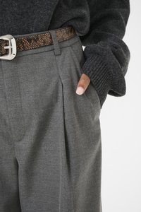 Gray tailored trousers with front pleats, paired with a dark knit sweater. A brown snakeskin-patterned belt adds detail.