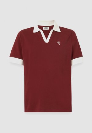 Burgundi polo marškiniai su balta apykakle ir rankogaliais. Yra V formos kaklo iškirptė ir mažas širdelės logotipas ant krūtinės. Pagaminti iš minkštos medžiagos.