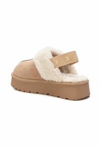 Infradito a piattaforma in suede beige con una soffice fascia foderata in pelliccia bianca, suola in gomma testurizzata e un elastico con logo.