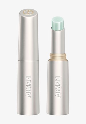Récipient argenté de baume à lèvres de la marque Armani avec un bouchon à côté du baume ouvert montrant un produit teinté vert clair.