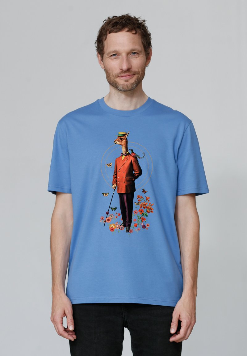 Blue cotton T-shirt featuring a giraffe in a brown suit and top hat, surrounded by colorful flowers and butterflies.