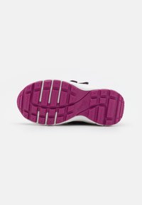 Weiße Sportschuhsohle mit einer pinken Gummisohle, die strukturierte Rillen und Muster für besseren Halt aufweist, sowie weißen Akzenten in der Nähe des Fußgewölbes.