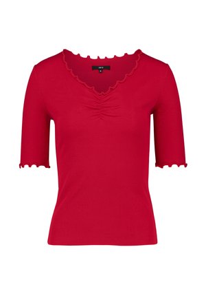 Haut rouge côtelé à manches courtes avec bords festonnés et léger froncement au centre de l'encolure.