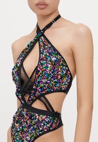 Zwarte bodysuit met meerkleurige pailletten, met een halternek en uitsnijdingen. Verstelbare band rond de nek voegt detail toe.
