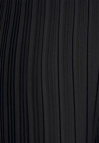 Tessuto nero plissé con strisce verticali, caratterizzato da una texture morbida e una profondità di colore uniforme. Nessun hardware visibile o ulteriori decorazioni.