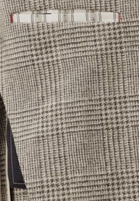 Gray checkered fabric features a textured weave with a subtle pattern. Includes a top pocket with a striped lining peeking out.