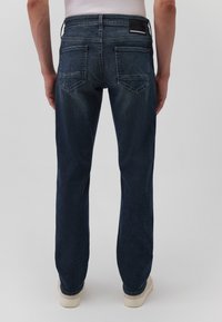 Dunkelblaue Jeans aus Denim mit geradem Bein. Zu den Merkmalen gehören Gesäßtaschen und ein Lederpatch mit einem gestreiften Akzent am Bund.