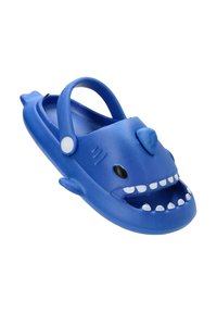 Sandalia de plástico azul en forma de tiburón, con una boca sonriente y dientes blancos, ojos negros y una correa en la parte trasera para mayor sujeción.