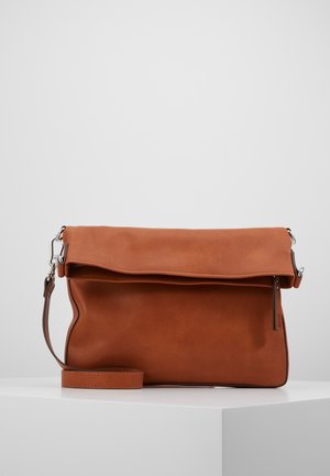 Sac bandoulière en cuir marron avec rabat, sangle détachable et fermoirs métalliques argentés, présenté sur un socle blanc sur fond uni.
