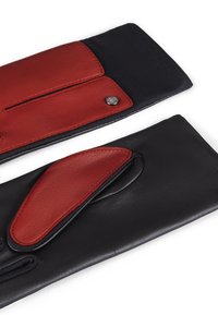 Guanti di pelle con un accento in pelle rossa su materiale nero, caratterizzati da un dettaglio di cucitura e un piccolo bottone metallico.