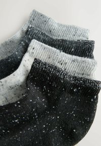 Négy pár bokaszakáll, eltérő szürke és fekete árnyalatokban, texturált anyagból, foltos mintákkal és fényvisszaverő szálakkal.