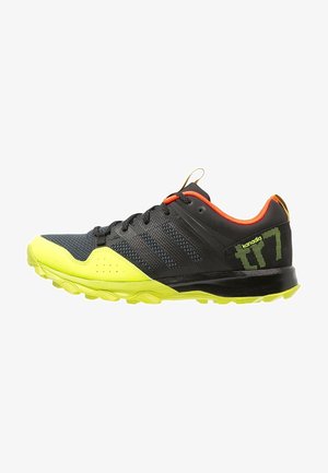 Chaussure de sport noire et jaune néon avec doublure intérieure orange, lacets noirs et semelle texturée, conçue pour la course en sentier ou les sports de plein air.