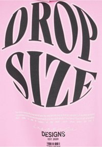 Schwarzer verzerrter Text "DROP SIZE" auf pinkem Hintergrund mit kleineren motivierenden Texten und "DESIGNS EST. 2020" darunter.