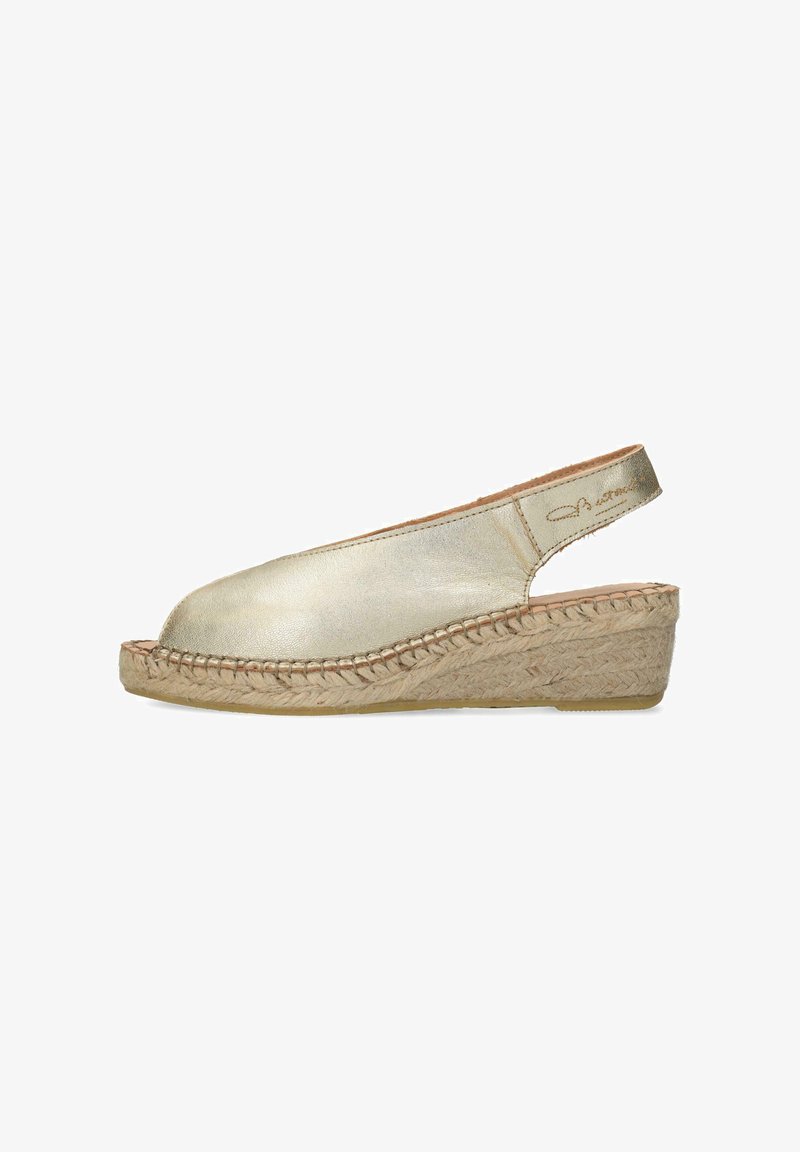 Espadrille en cuir doré à talon compensé en jute. Design ouvert avec des détails tressés et une texture lisse.