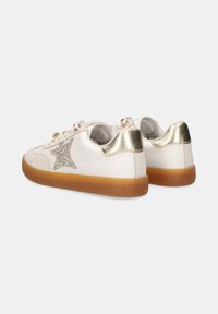 Zapatillas de cuero blanco con un acento dorado en el talón y un detalle de estrella plateada brillante. Presenta una suela de goma y un sistema de cordones en la parte frontal.