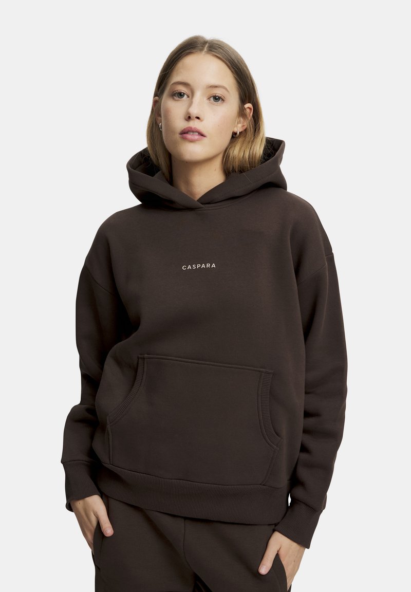 Brun huvtröja med kängurufickor, med en liten vit "CASPARA"-logotyp på bröstet. Mjuk material, avslappnad passform.