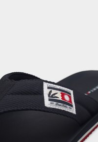 Μαύρο σανδάλι Tommy Hilfiger slide με υφασμάτινο λουράκι που διαθέτει κεντημένο λογότυπο και επένδυση στο πέλμα για άνεση.