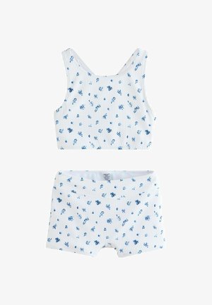 Bijeli rebrasti komplet kratke majice i kratkih hlača s malim plavim cvjetnim uzorkom, dizajniran za djecu.