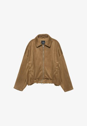 Hnedá bunda z imitácie semišu s golierom, predným zipsom a bočnými vreckami. V páse je opasok a rukávy sú voľné, nadmerne veľké.