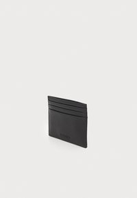 Portafoglio in pelle nera con più slot per carte, design slim e texture liscia con un discreto marchio in rilievo.